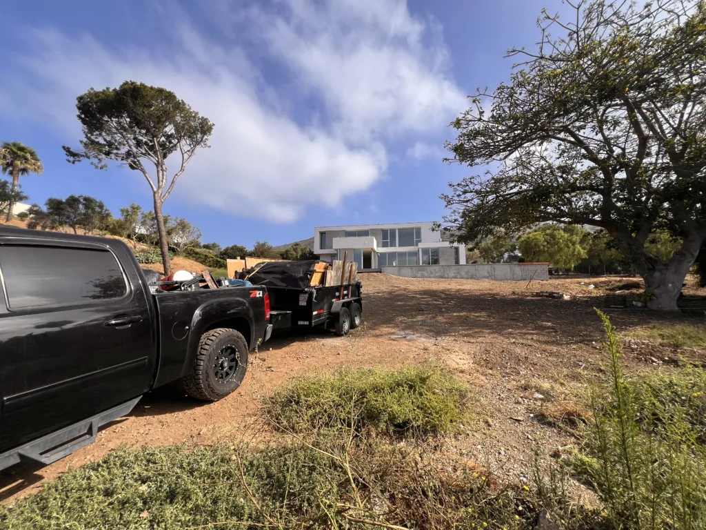 Dump trailer loaded with construction debris being hauled away from Malibu luxury home