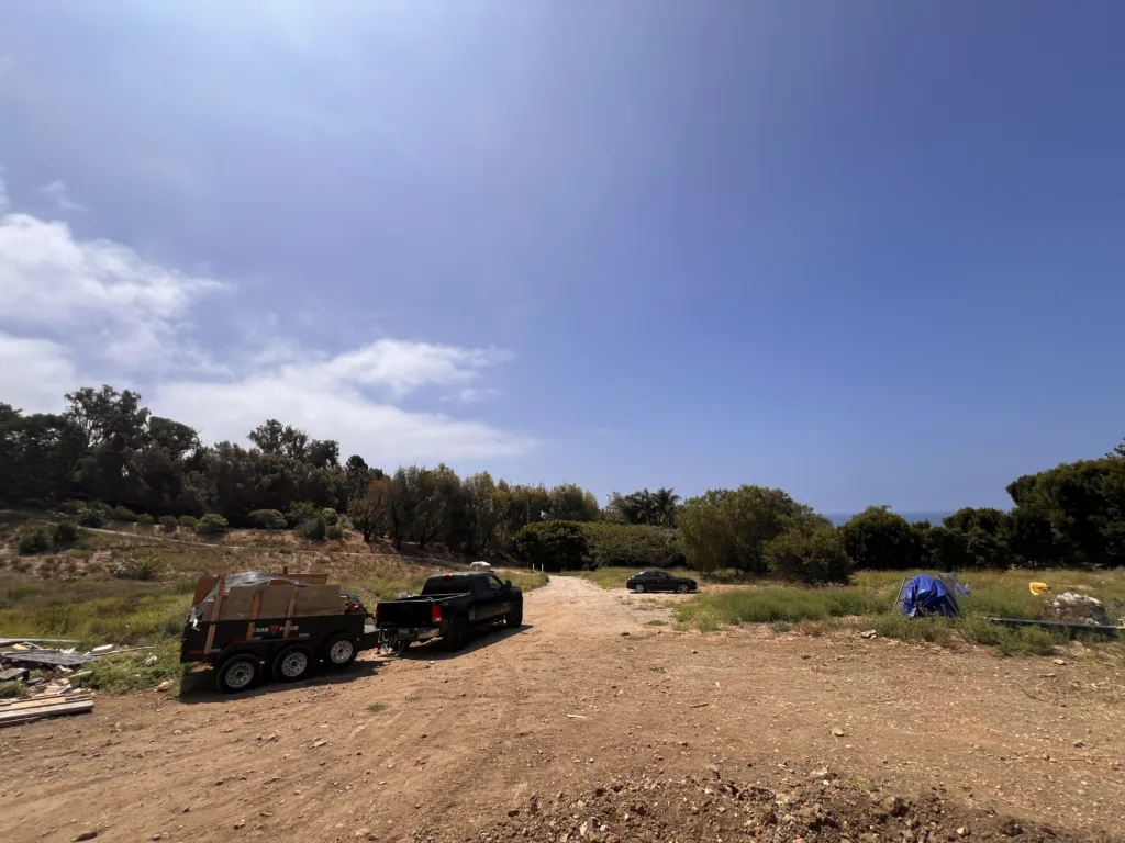 Truck and dump trailer viewed from Malibu luxury home overlooking ocean